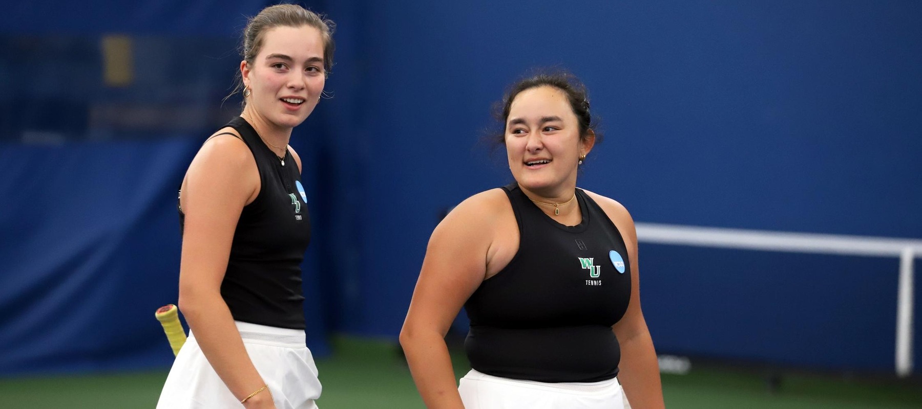 Photo of Ines Oliveira (left) and Siana MacDonald who won at No. 3 doubles to clinch the doubles point for the Wildcats on Saturday. Copyright 2026; Wilmington University. All rights reserved. May 9, 2026 at Queens. Photo courtesy of Navraj Sandhu at Queens.